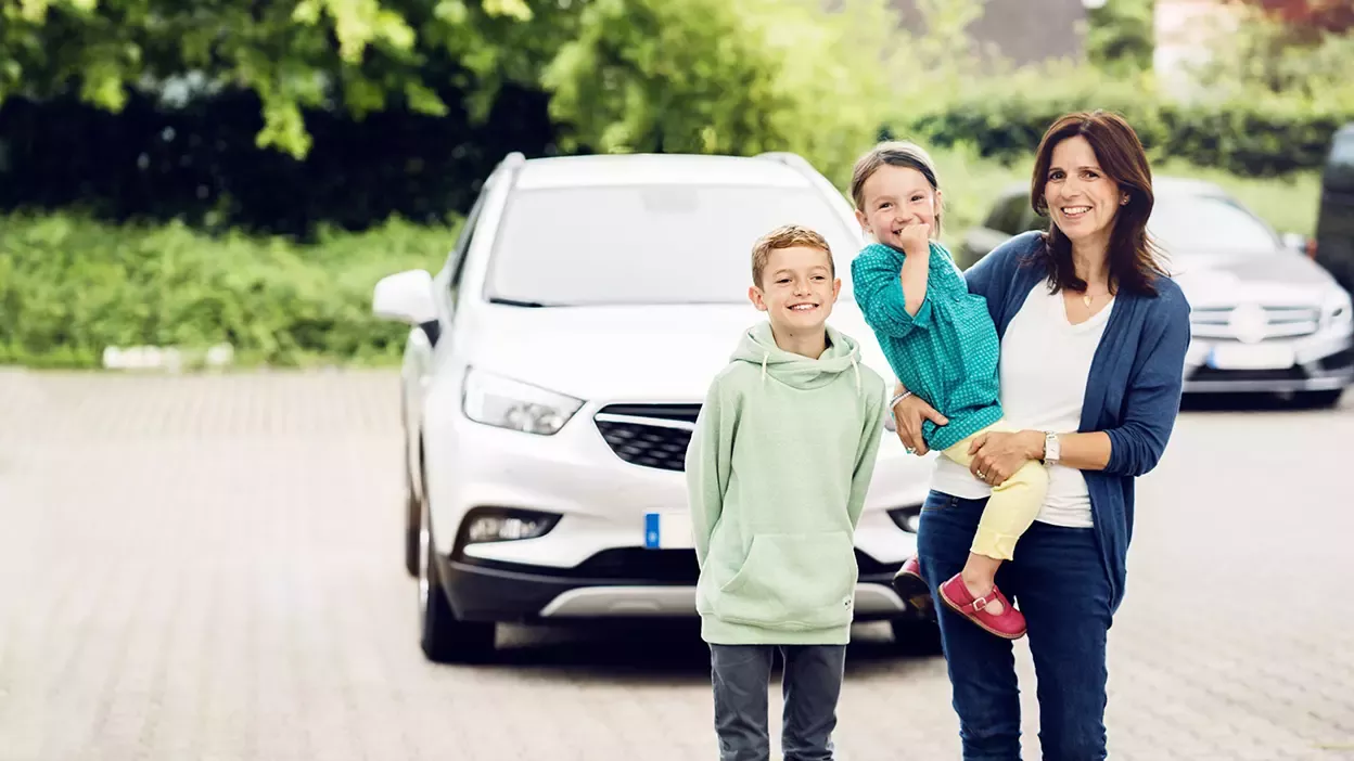 fröhliche Familie vor Auto